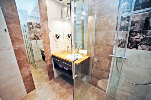 ソポトにあるAmber Apartment by Grand Apartmentsのバスルーム(洗面台、ガラス張りのシャワー付)