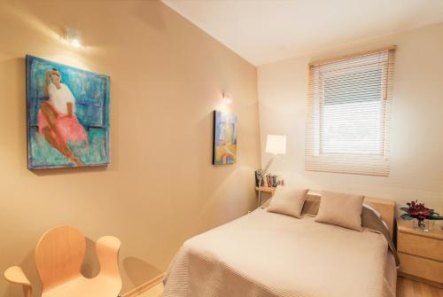 ソポトにあるGracja Apartment by Grand Apartmentsのベッドルーム1室(ベッド1台付)が備わります。壁には絵画が飾られています。