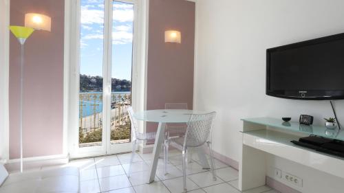 Cette chambre dispose d'une table, d'une télévision et d'une fenêtre. dans l'établissement Résidence Rauba Capeu, à Nice