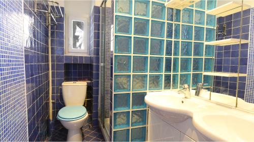 ニースにあるRésidence Rauba Capeuの青いタイル張りのバスルーム(トイレ、シンク付)