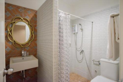 a bathroom with a shower and a toilet and a sink at The O-Zone Airport Inn in Ban Khlong Prawet