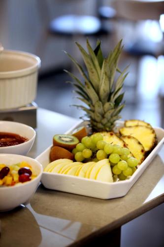 a plate of fruit on a table with a pineapple at Hotell Conrad in Karlskrona