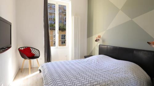 een slaapkamer met een bed, een stoel en een raam bij Apartment Port in Nice