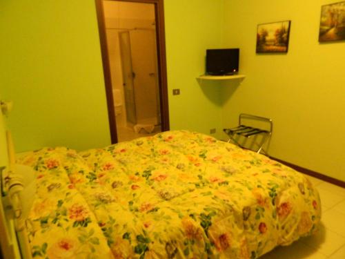 a bedroom with a bed with a flowered blanket at Albergo Michieletto in Valmorea