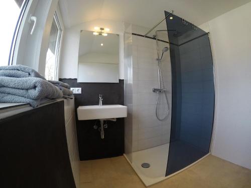 La salle de bains est pourvue d'une douche et d'un lavabo. dans l'établissement Holiday Home Kötz, à Guntzbourg