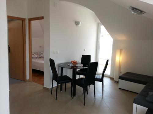 ein Esszimmer mit einem Tisch und Stühlen sowie ein Schlafzimmer in der Unterkunft Apartment STAR in Novalja
