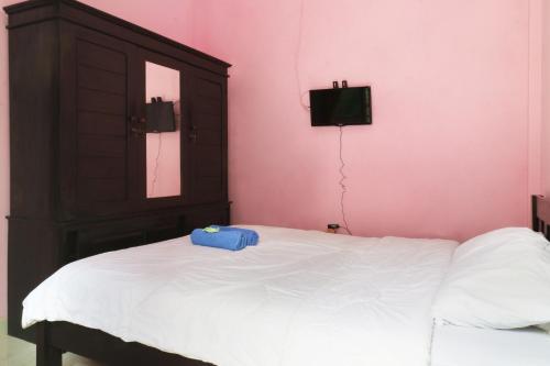 أنانتايا هوم في دينباسار: غرفة نوم مع سرير عليها صندوق ازرق