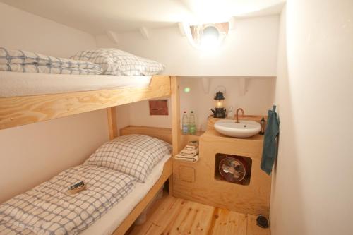 Kleines Zimmer mit 2 Etagenbetten und einem Waschbecken in der Unterkunft Klabauterbett in Bremen