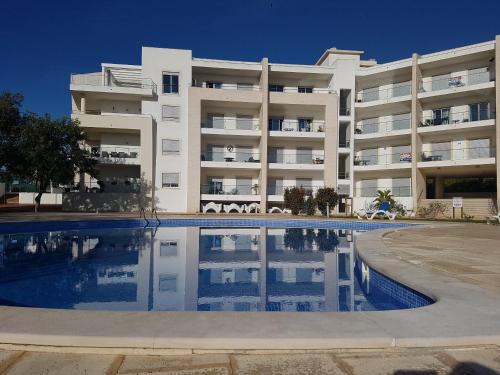un immeuble d'appartements avec une piscine en face dans l'établissement Monte da Eira, à Albufeira
