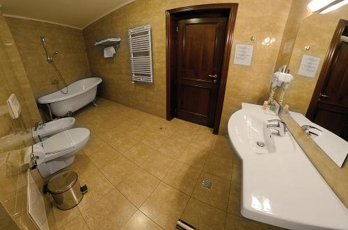 a bathroom with two toilets and a sink and a tub at Hotel Diesel in Bucharest