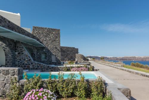 a house with a swimming pool and flowers at Elements of Caldera Suites in Akrotiri