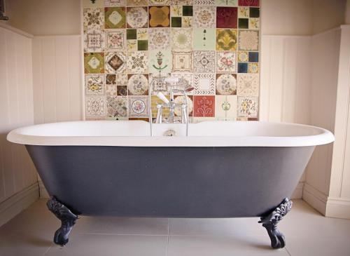 y baño con bañera y pared de azulejos. en The White Hart en Somerton