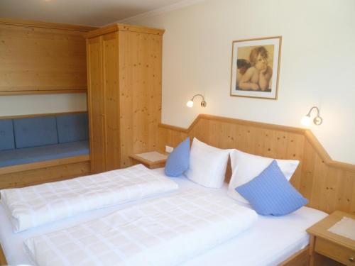 a bedroom with two beds with blue and white pillows at Appartement Alpenhof Wildschönau in Niederau