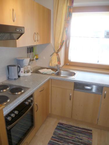 a small kitchen with a sink and a stove at Appartement Alpenhof Wildschönau in Niederau