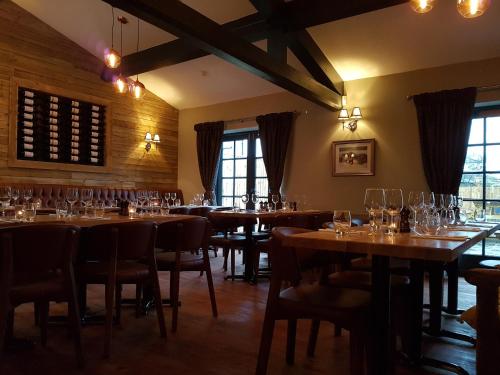 a restaurant with wooden tables and chairs with wine glasses at The Angel Inn in Warminster