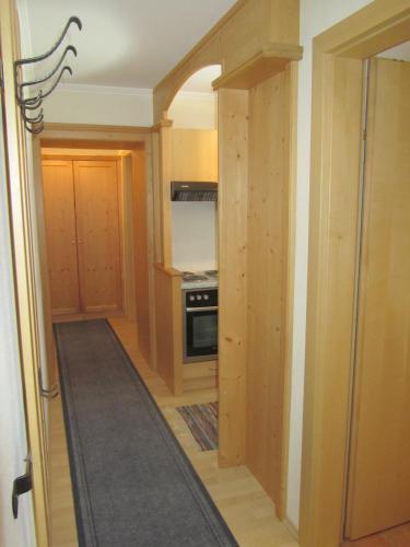 a kitchen with an open door into a kitchen with a stove at Appartement Alpenhof Wildschönau in Niederau