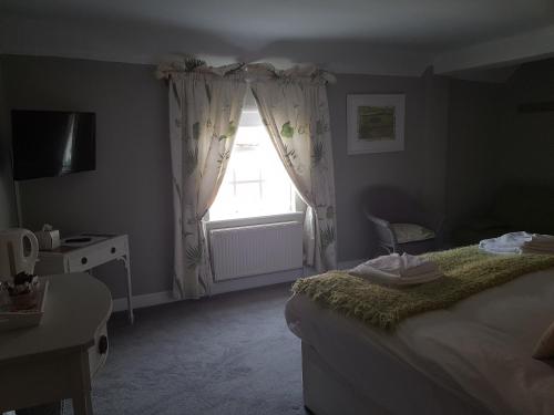 a bedroom with a bed and a window at The Angel Inn in Warminster