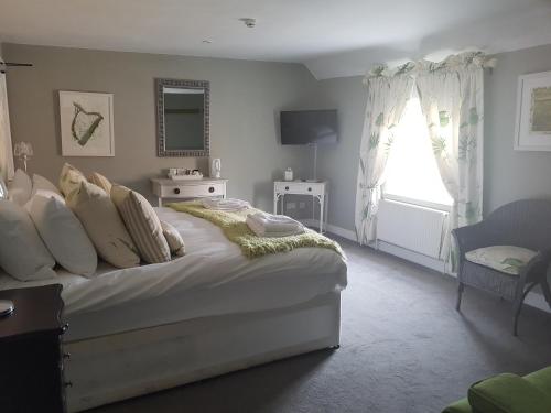 a bedroom with a large bed with a window at The Angel Inn in Warminster