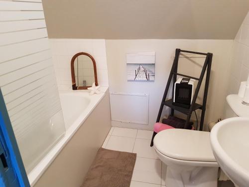 un bagno con vasca, WC e lavandino di La Petite Parenthèse a Honfleur
