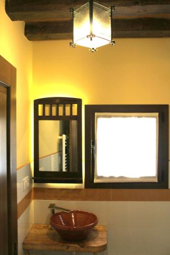 a bathroom with a bowl on a table and two windows at Posada Ignatius in Navarrete