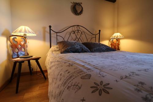 SchillersdorfにあるChambres d'Hôtes S'burehieselのベッドルーム1室(ベッド1台、テーブルにランプ2つ付)
