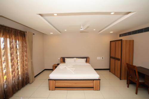 a bedroom with a bed and a wooden cabinet at Hotel Golden Gateway in Vellore