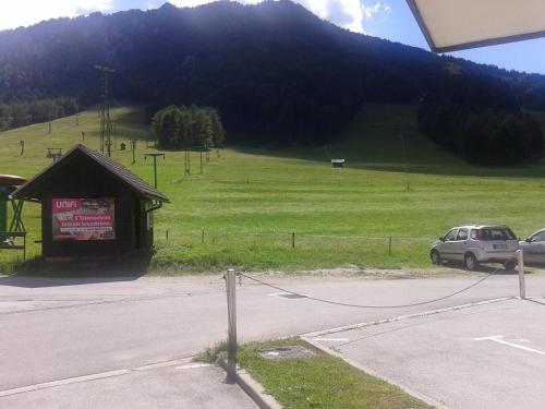 a car parked in front of a building in a field at Apartments Blažič in Kranjska Gora
