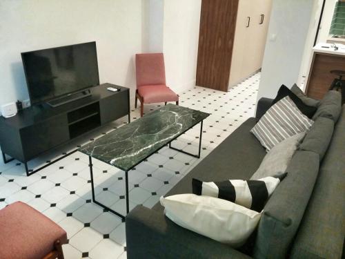 salon z kanapą i telewizorem z płaskim ekranem w obiekcie Central new Kolonaki apartment w Atenach
