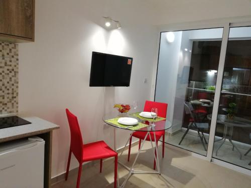 a small kitchen with a table and chairs and a tv at Chicos Studios in Ayia Napa