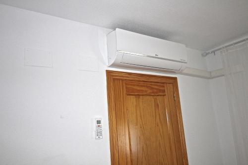 a room with a ceiling fan and a wooden door at Residence Vacanza Torre Monaco in Benidorm