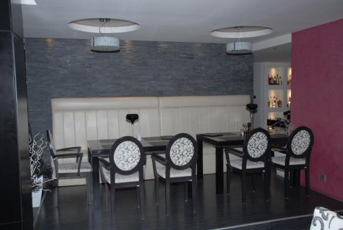 a dining room with a black table and chairs at B&B Rose in Vranje