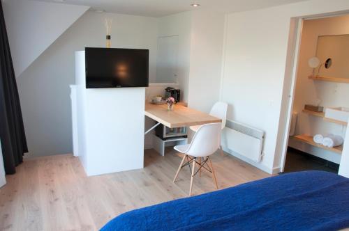 a room with a table and a desk with a refrigerator at B&B Aquavit in Knokke-Heist