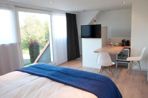 een slaapkamer met een bed met een blauwe deken erop bij B&B Aquavit in Knokke-Heist