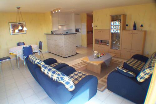 sala de estar con 2 sofás azules y cocina en Residence Calidris ref 48, en Koksijde