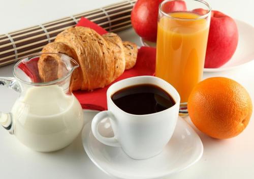 un tavolo con una tazza di caffè e un piatto di cibo di Hôtel Club MMV Les Brévières a Tignes