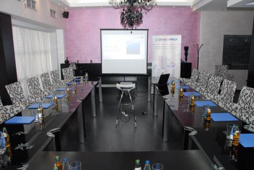 a meeting room with tables and chairs and a screen at B&B Rose in Vranje