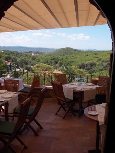 a restaurant with tables and chairs and a view of the mountains at Hotel Galena Mas Comangau in Begur