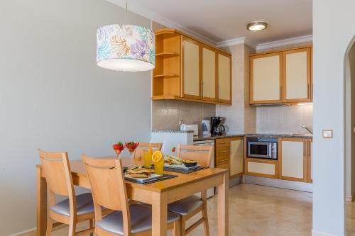a kitchen and dining room with a wooden table and chairs at The Navigator - Solaqua in Albufeira