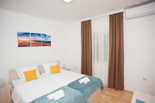 a bedroom with a large white bed and a window at Vila Vanila in Gevgelija