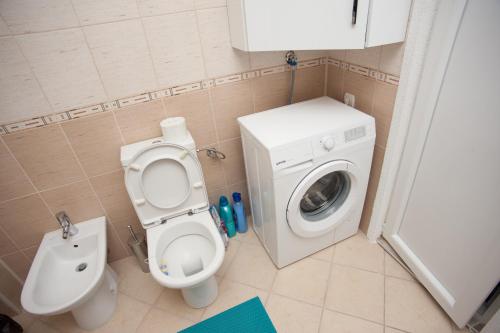 a bathroom with a toilet and a washing machine at Vila Vanila in Gevgelija