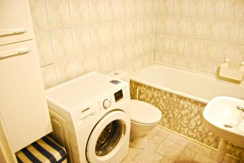 a bathroom with a toilet and a washing machine at HelApart - Helium in Hel