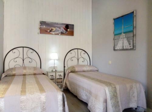 ピエドライタにあるCasa Rural Neveritasのベッドルーム1室(ベッド2台、壁掛けテレビ付)