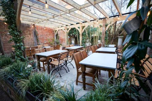 a patio with tables and chairs under a greenhouse at Wykeham Arms in Winchester