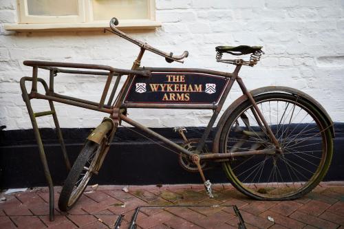 a bike with a sign on the side of a building at Wykeham Arms in Winchester