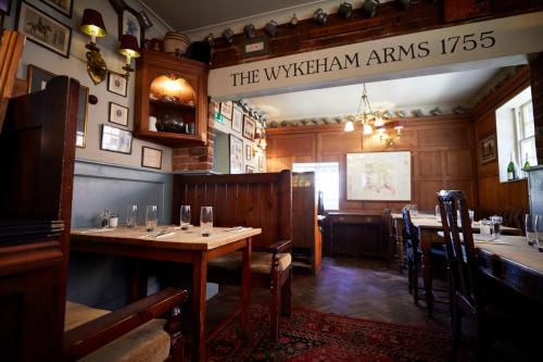 a dining room with tables and chairs in a restaurant at Wykeham Arms in Winchester
