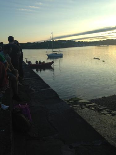 a group of people watching a boat in the water at Summer Cottage in Kinsale Free Car Parking Included in Kinsale