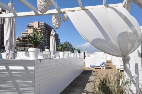 a white rooftop bar with white umbrellas and plants at B&B Aquavit in Knokke-Heist