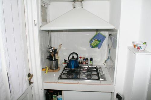 un fornello in una piccola cucina con un vaso sopra di Casetta bianca sul mare a Bogliasco