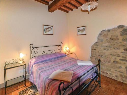 1 dormitorio con cama y pared de piedra en Agriturismo Borgo Del Senatore, en Anghiari