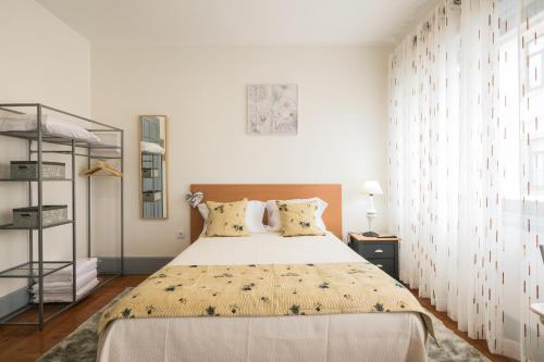 um quarto com uma cama grande num quarto branco em A Francos Burguer Station 2 no Porto